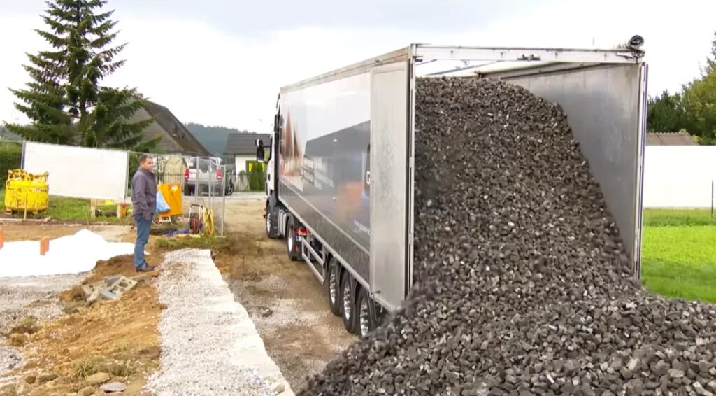 Camion descărcând sticlă celulară expandată GEOCELL Grey pe un șantier rezidențial pentru realizarea unui strat suport drenant și termoizolant