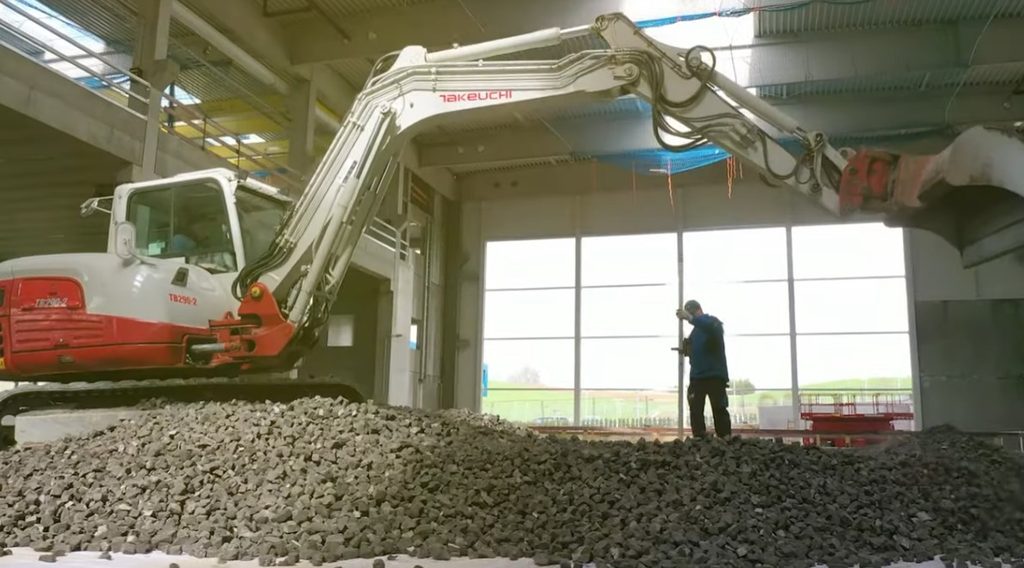 Umplutură ușoară din sticlă celulară pusă în operă cu excavatorul într-o construcție